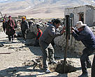 Labourers dig holes for fence posts around Lhasang's home to protect his family from potential brown bear attacks. 